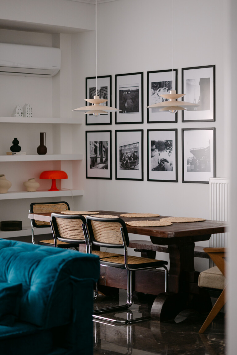 Dining table with rattan chairs and black-and-white photo gallery wall