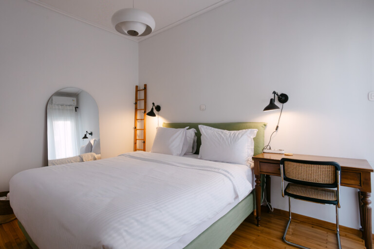 Double bedroom with desk, reading lamp and arched mirror