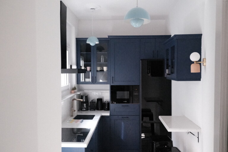 Compact navy blue kitchen with modern appliances