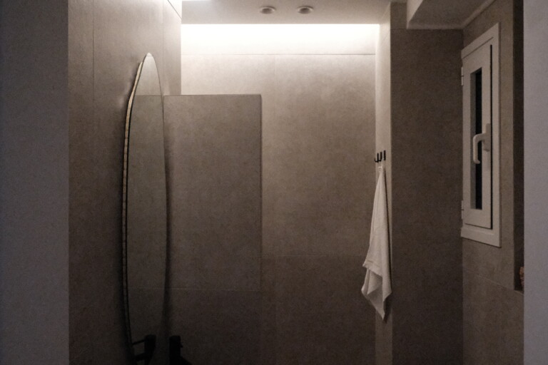 Walk-in shower in a modern stone-tiled bathroom