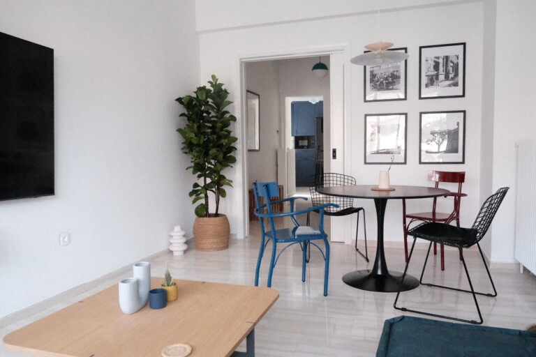 Dining corner with round table, blue chairs and framed photographs